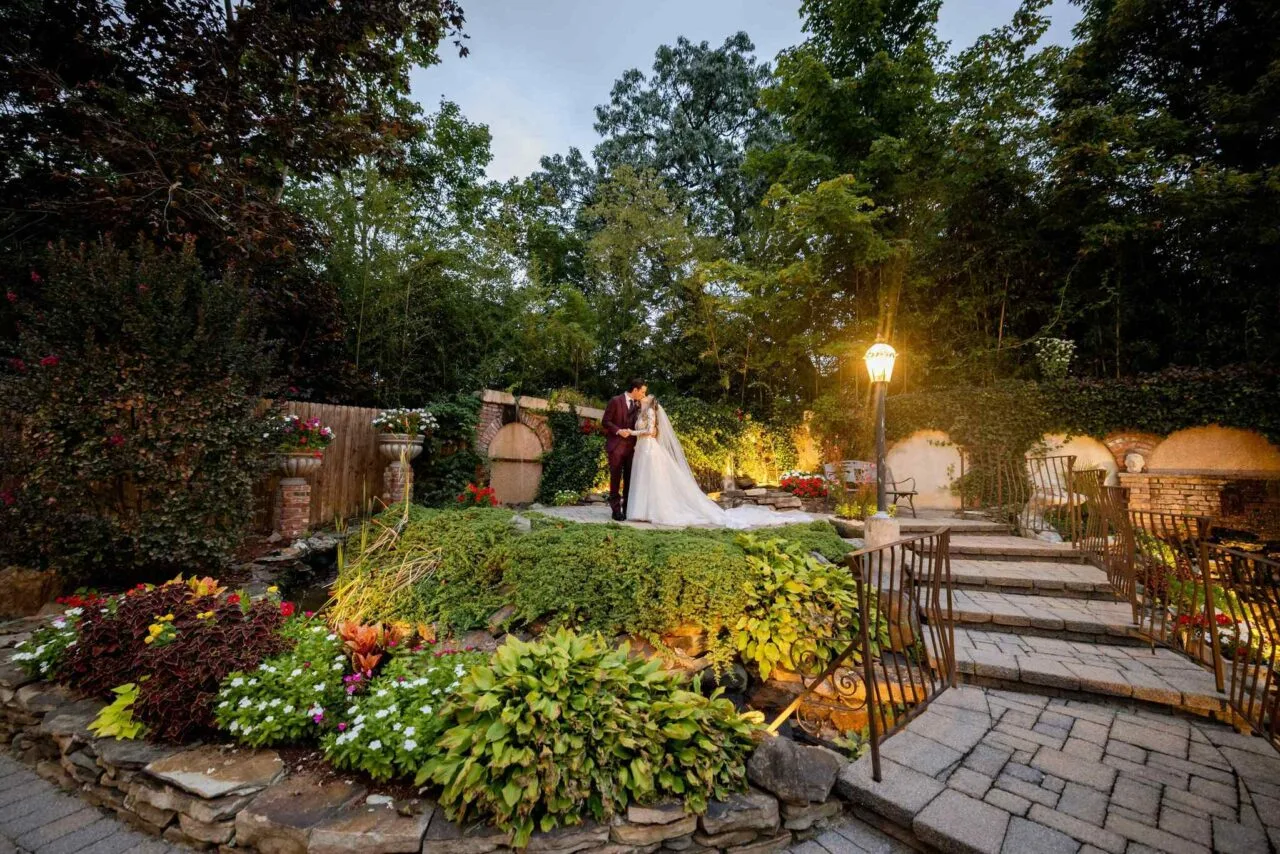 Bride and groom sitting on a bench in a rustic courtyard on their wedding day

