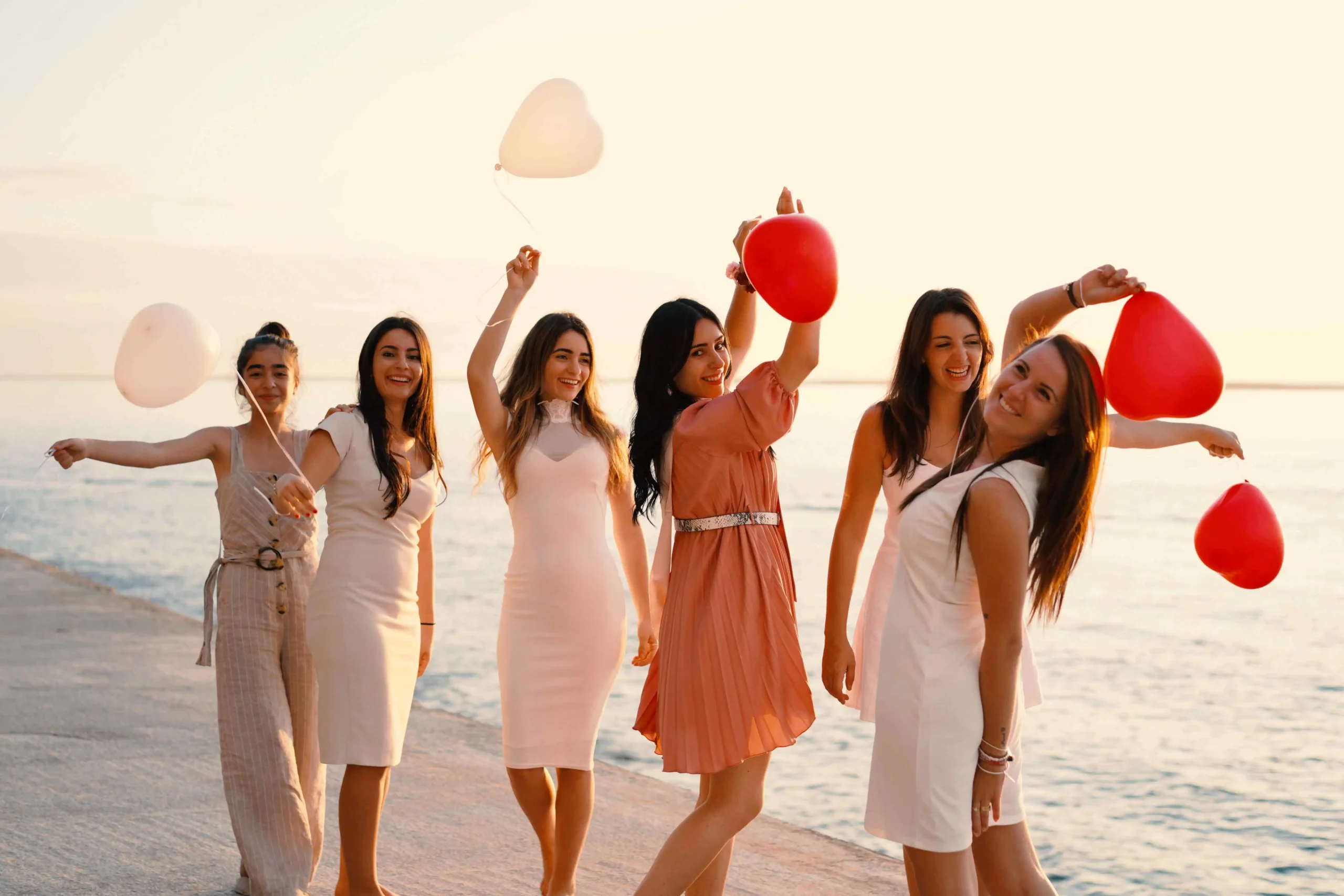 Bridesmaids holding balloons on beach